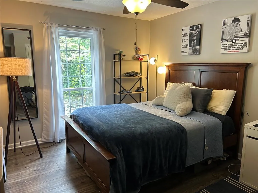 Bedroom with wood finished floors, a textured ceiling, and ceiling fan
