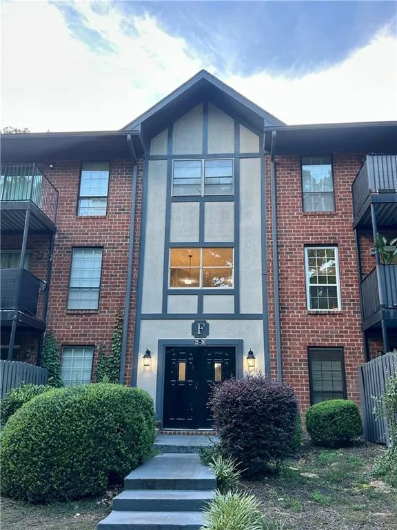 Entrance to property with brick siding and stucco siding