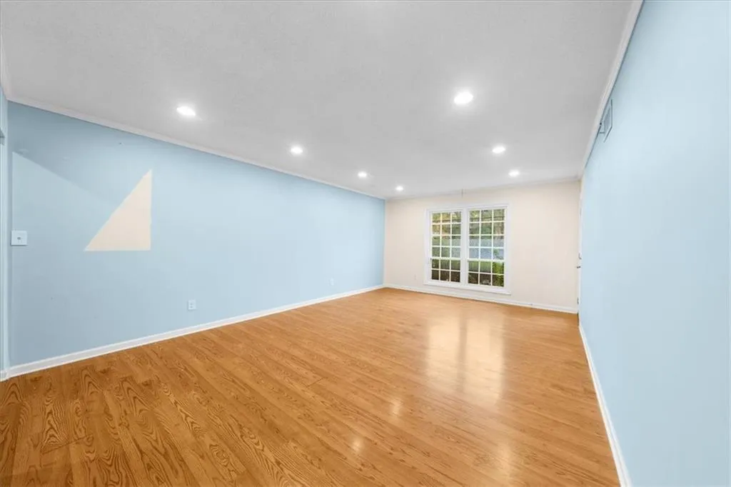 Empty room with light wood-type flooring and ornamental molding Empty room with light wood-type flooring and ornamental molding
