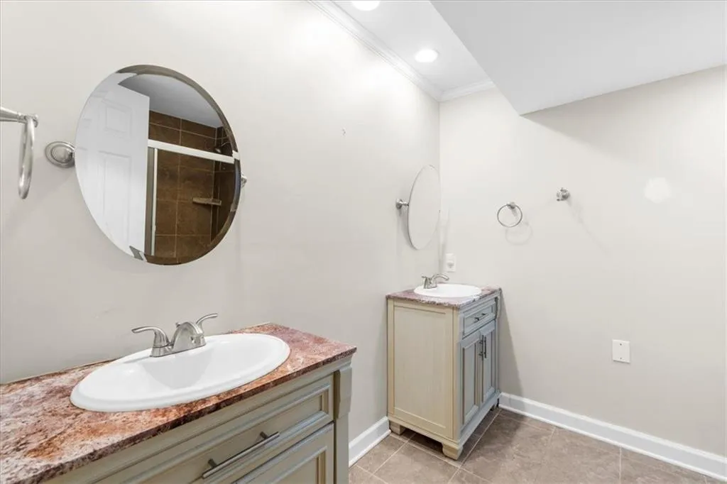 Bathroom with tile patterned flooring, vanity, and crown molding Bathroom with tile patterned flooring, vanity, and crown molding