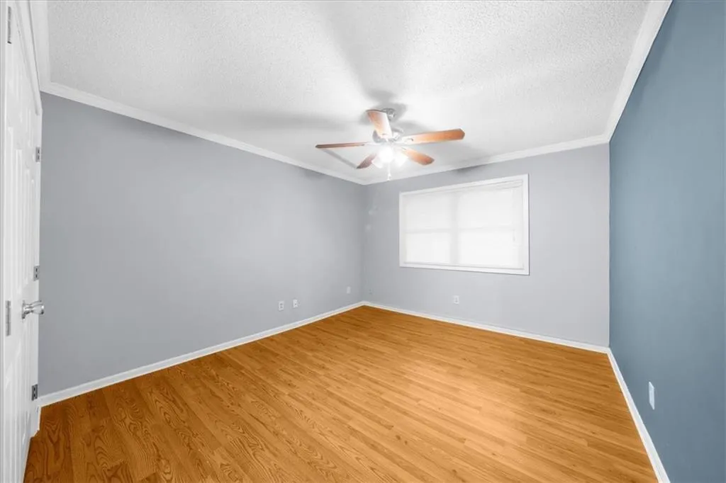 Unfurnished room with ceiling fan, light wood-type flooring, and a textured ceiling Unfurnished room with ceiling fan, light wood-type flooring, and a textured ceiling