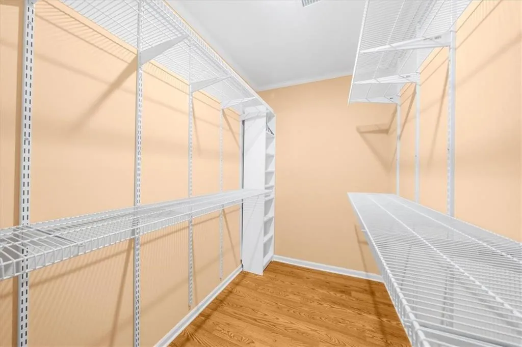 Walk in closet with hardwood / wood-style floors Walk in closet with hardwood / wood-style floors