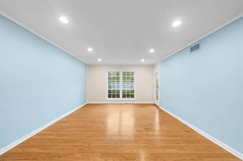 Empty room featuring crown molding and light hardwood / wood-style flooring Empty room featuring crown molding and light hardwood / wood-style flooring