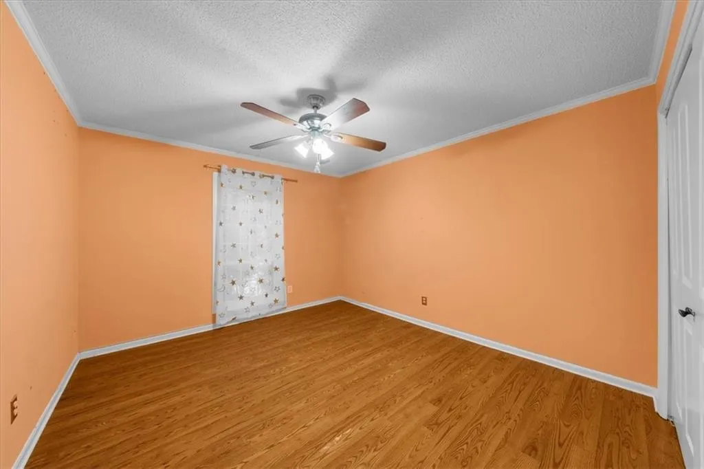 Unfurnished room with a textured ceiling, hardwood / wood-style flooring, and ceiling fan Unfurnished room with a textured ceiling, hardwood / wood-style flooring, and ceiling fan