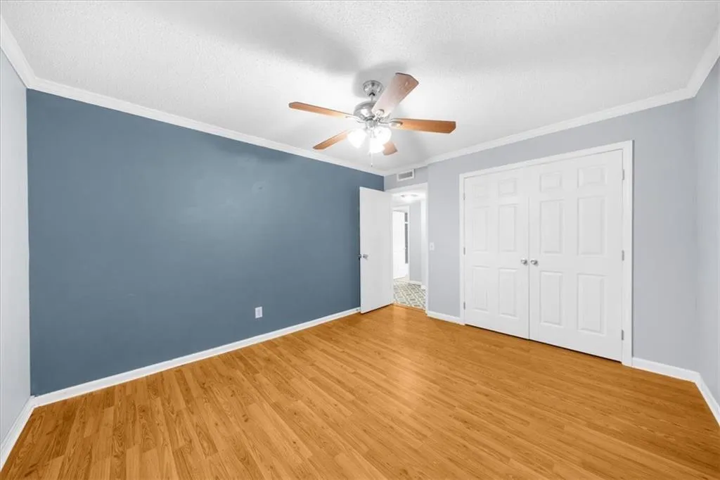 Unfurnished bedroom featuring a closet, light hardwood / wood-style flooring, ceiling fan, and crown molding Unfurnished bedroom featuring a closet, light hardwood / wood-style flooring, ceiling fan, and crown molding