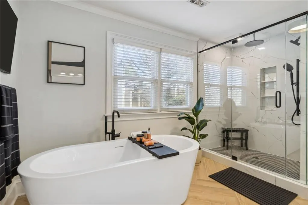 Bathroom featuring parquet flooring, ornamental molding, separate shower and tub, and a healthy amount of sunlight
