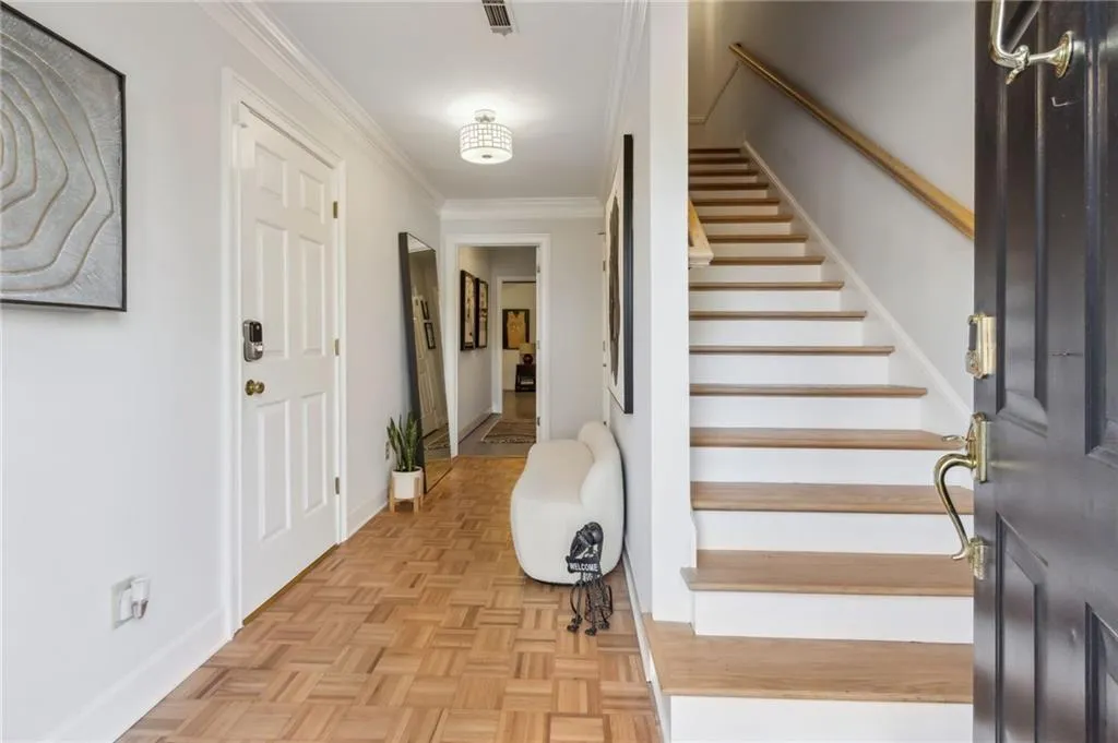 Foyer with light parquet flooring and ornamental molding