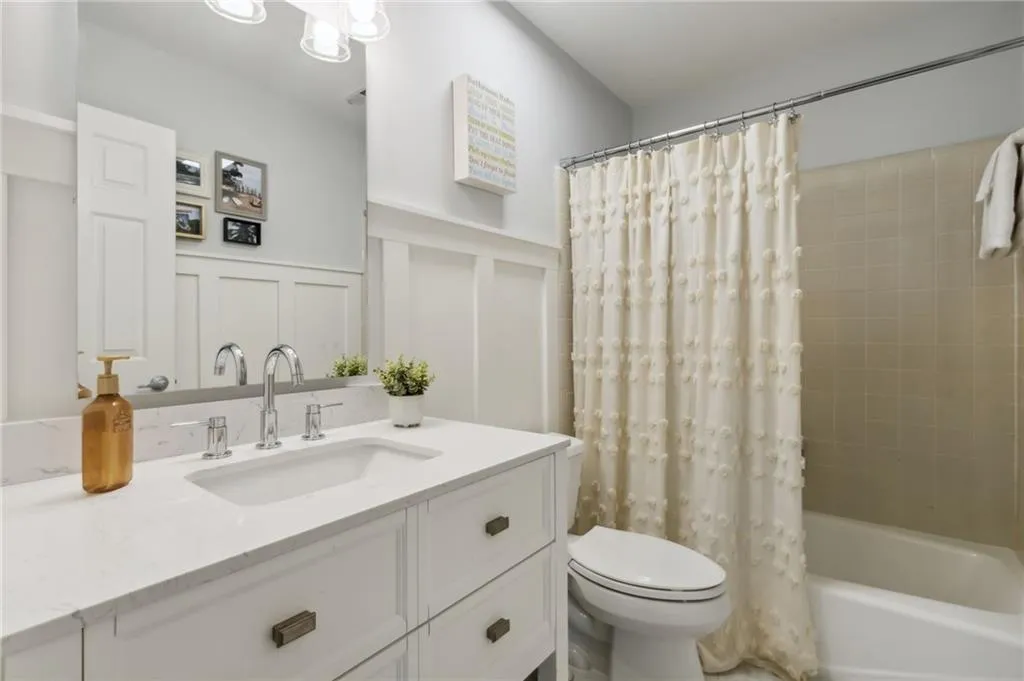 Full bathroom with shower / bath combo with shower curtain, toilet, and oversized vanity