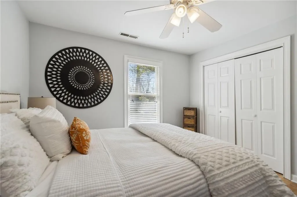 Bedroom with radiator heating unit, a closet, and ceiling fan