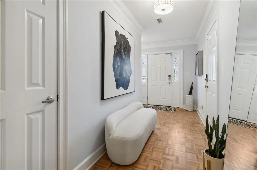 Entrance foyer with light parquet floors and crown molding