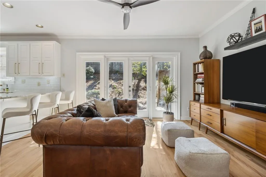 Living room with crown molding, light hardwood / wood-style flooring, and ceiling fan