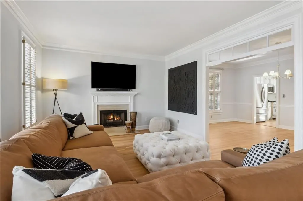 Living room with plenty of natural light, a chandelier, and light hardwood / wood-style floors