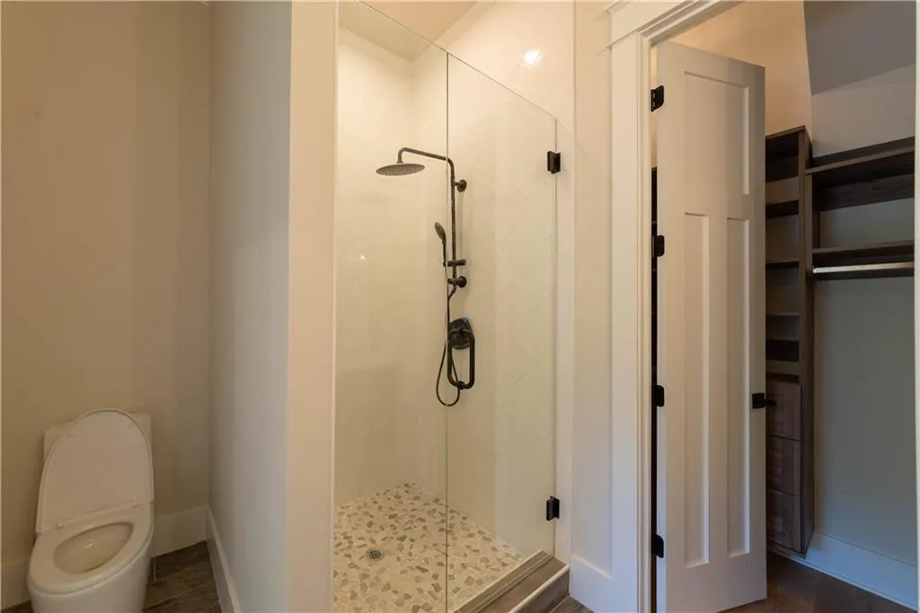Bathroom featuring an enclosed shower and toilet