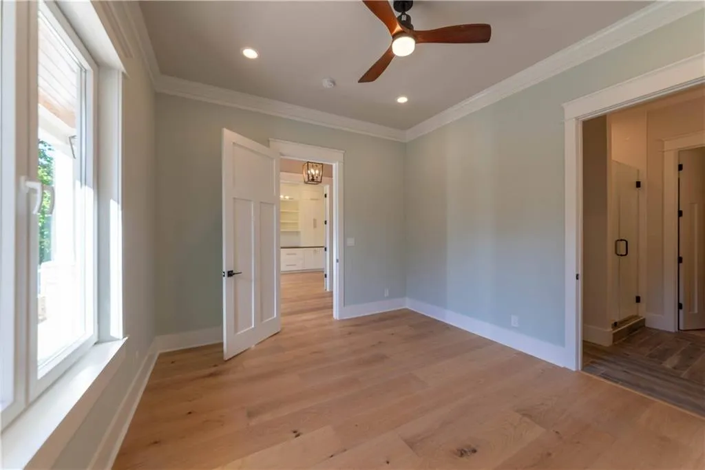 Unfurnished room with ceiling fan, light hardwood / wood-style flooring, and ornamental molding