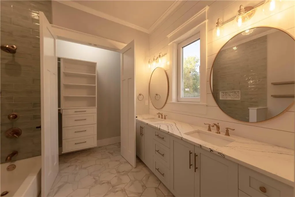 Bathroom with shower / bathing tub combination, crown molding, and vanity