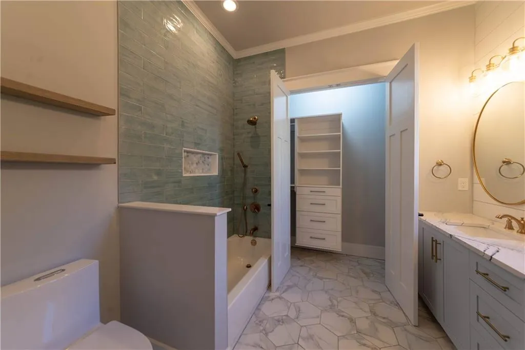 Bathroom with crown molding, vanity, and toilet