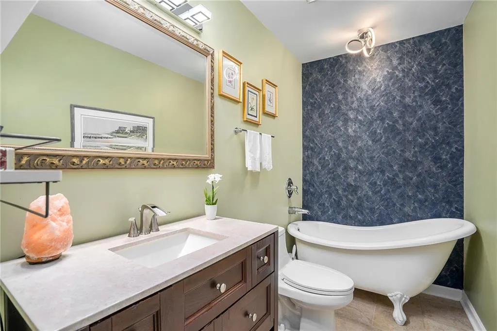Bathroom featuring vanity, clawfoot soaker tub, tile flooring