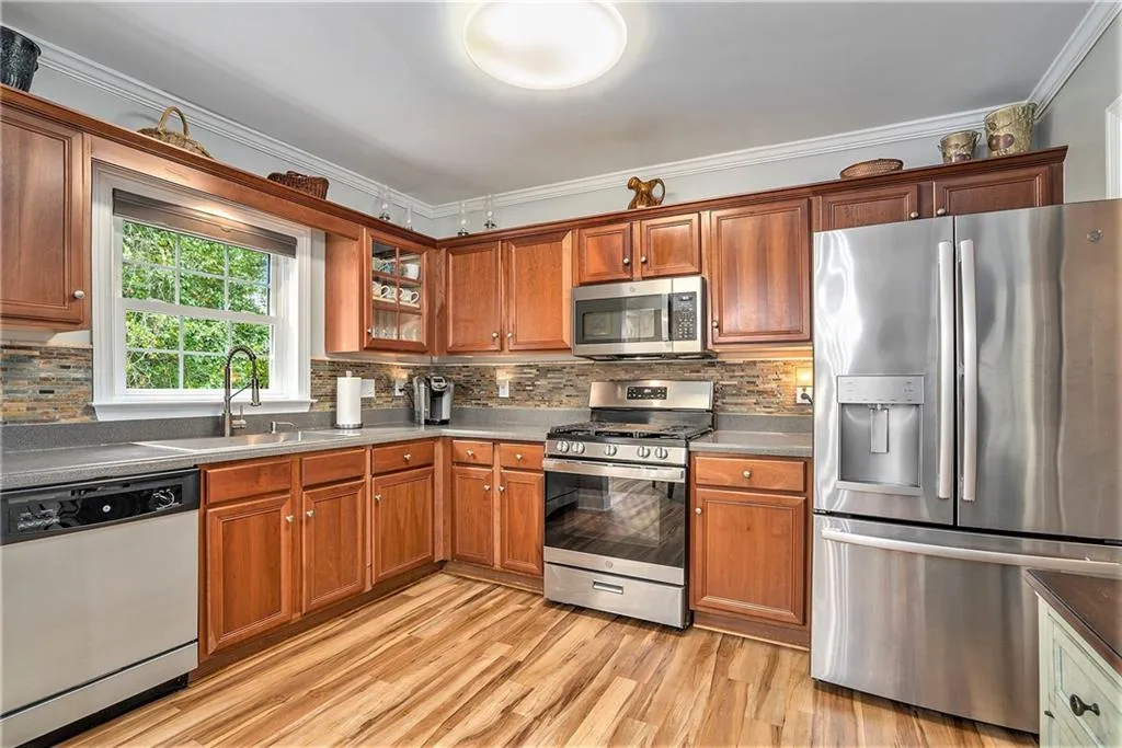 Kitchen with stainless steel appliances decorative backsplash, ornamental molding