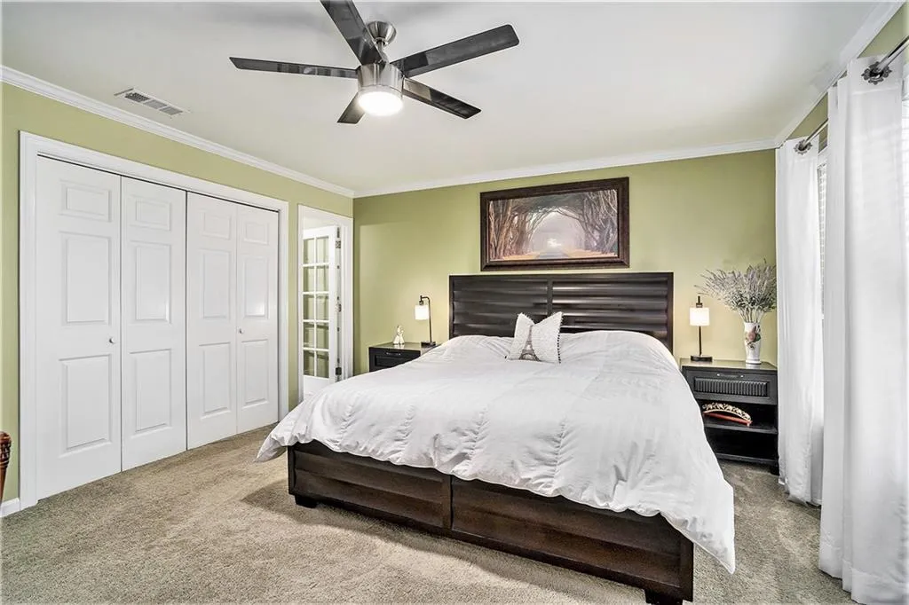 Both bedrooms have crown molding, light colored carpet, and ceiling fans