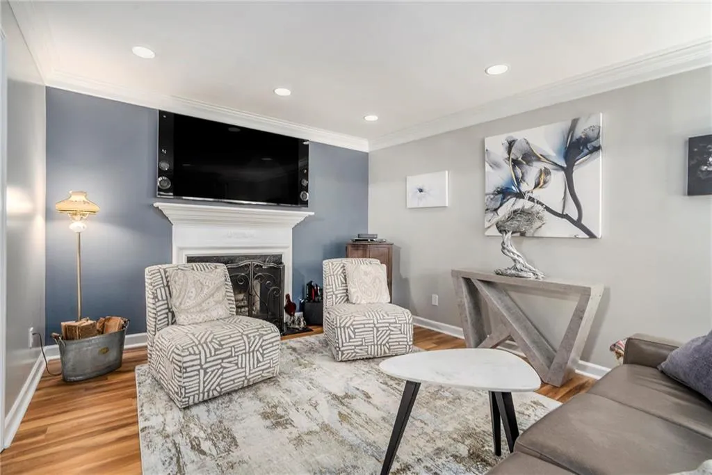 Spacious family room featuring wood-type flooring, fireplace, and ornamental molding