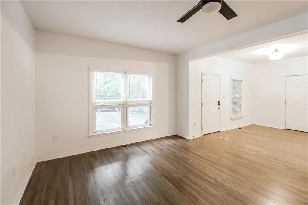 Empty room featuring hardwood / wood-style flooring and a ceiling fan