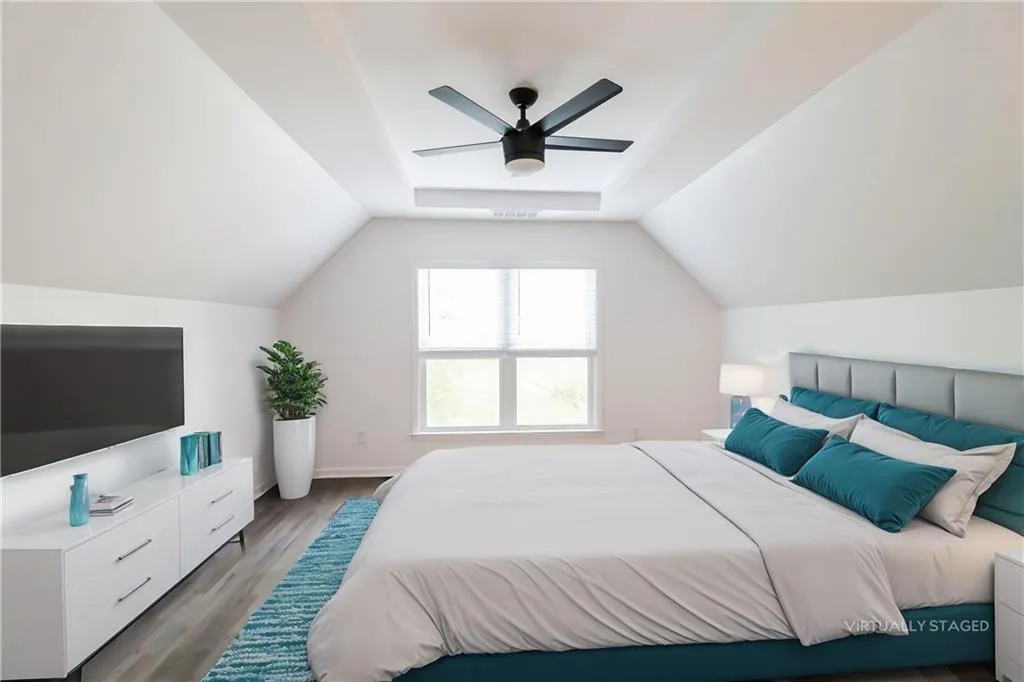 Bedroom featuring wood finished floors, a ceiling fan, and vaulted ceiling