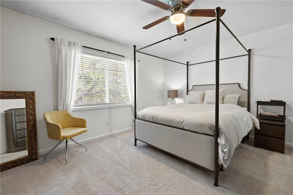 Carpeted bedroom featuring baseboards and a ceiling fan