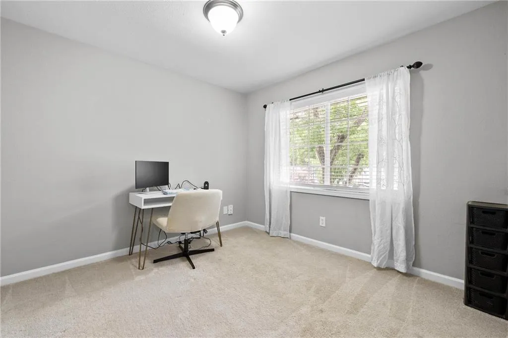 Carpeted office space with baseboards