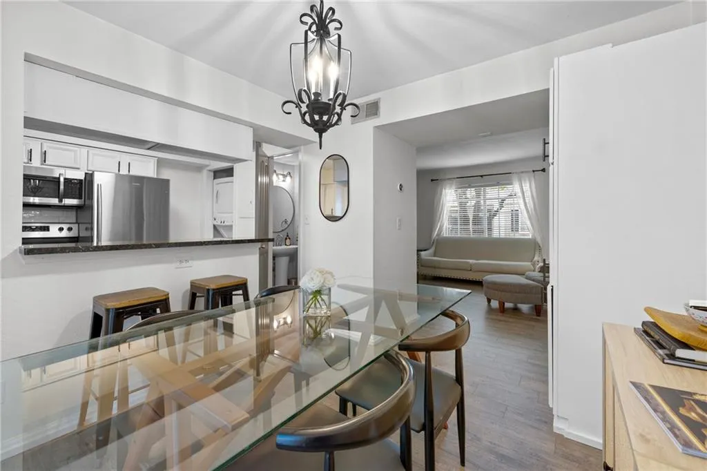 Dining space with dark wood finished floors and a chandelier