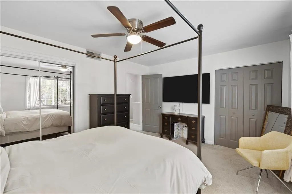 Carpeted bedroom featuring a ceiling fan