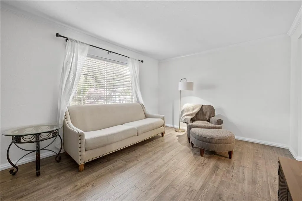 Sitting room with wood finished floors and ornamental molding
