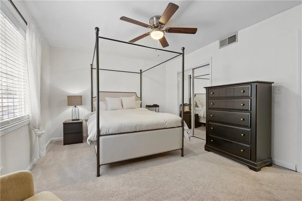 Bedroom featuring light carpet, ceiling fan, and a closet