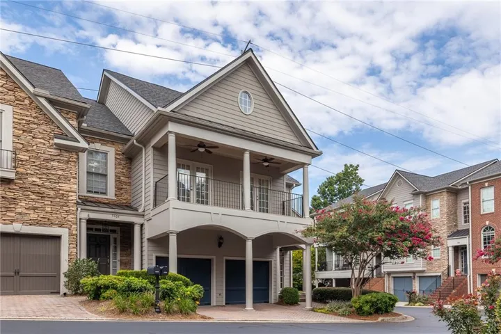 Multi-level townhome featuring stone and siding exterior with a pitched roof