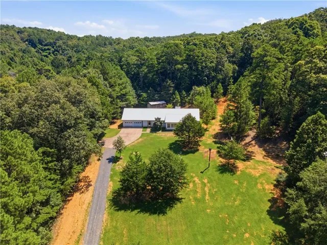 Ranch-style residence featuring a metal roof, attached two-car garage, and a gravel driveway