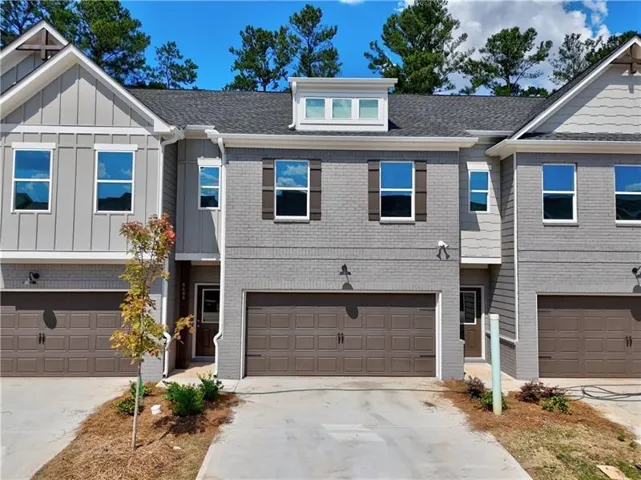 Contemporary townhome exterior featuring gray brick and vertical siding accents