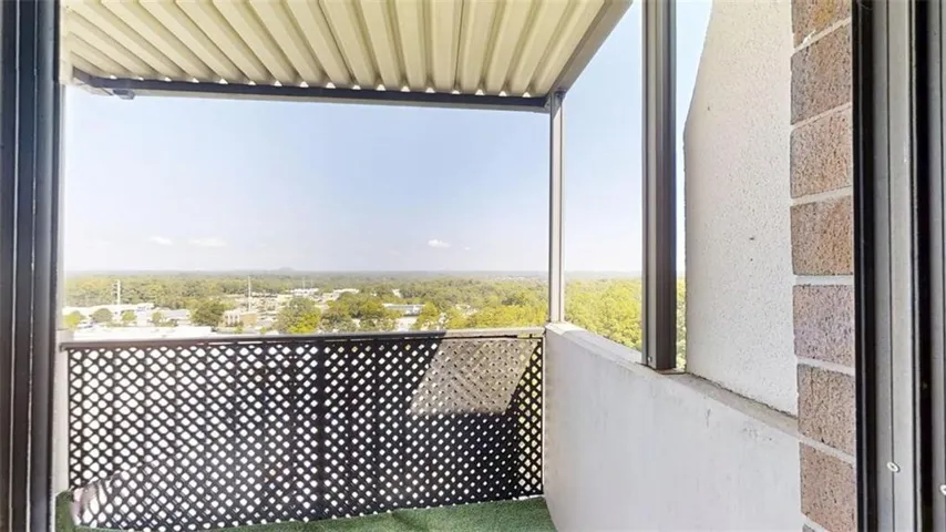 Balcony with a lattice railing, overhead covering, and a panoramic urban landscape
