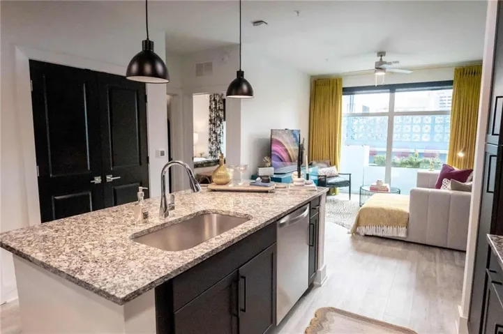 Kitchen with light hardwood / wood-style flooring, sink, ceiling fan, a kitchen island with sink, and stainless steel dishwasher