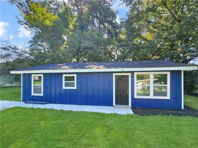 Blue siding exterior with white trim and a dark entry door
