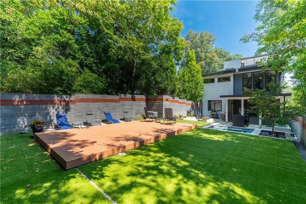 Pool area with turf yard and custom sliding deck covering pool