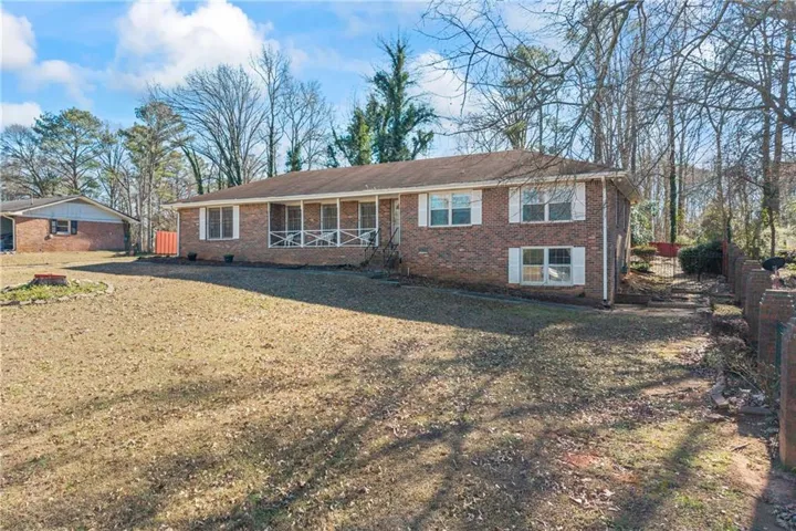 Brick exterior with white shutters, screened porch, and gabled roof