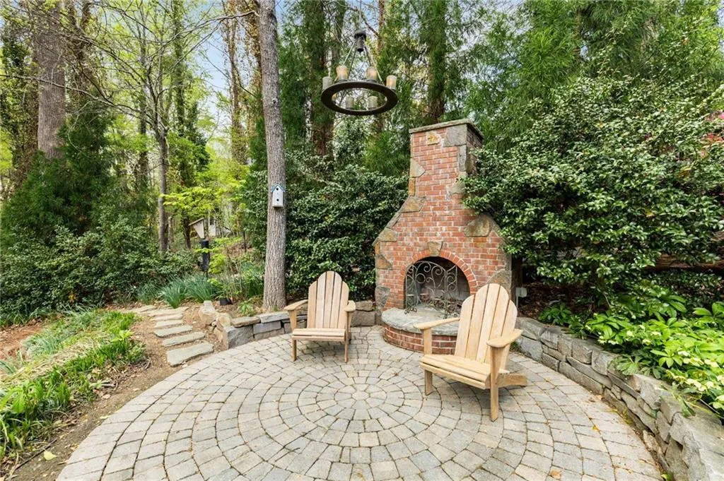 View of patio featuring an outdoor brick fireplace with chandelier!
