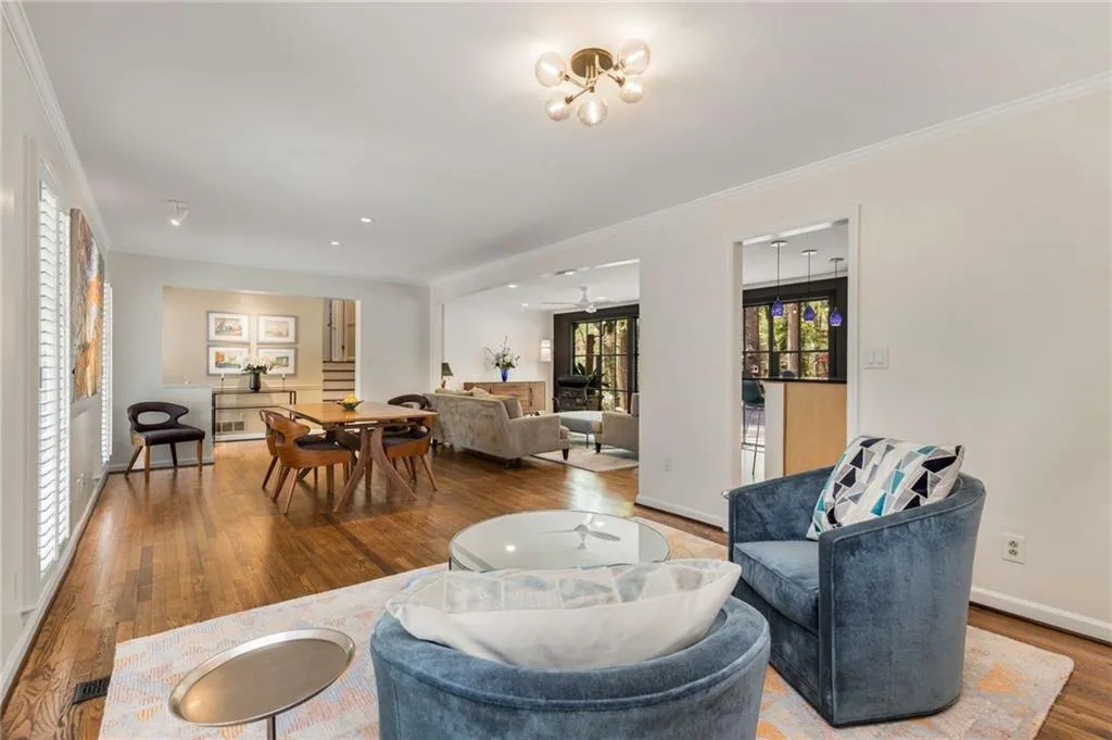 Living area featuring ornamental molding, baseboards, a ceiling fan, and wood finished floors