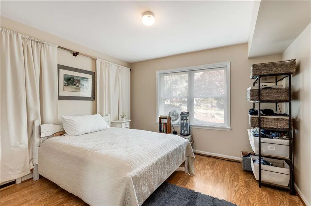 Lower Level Bedroom with view to front yard.  Wood floors and closet