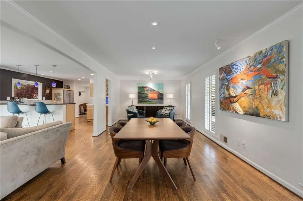 Dining space featuring ornamental molding, visible vents, baseboards, and wood finished floors