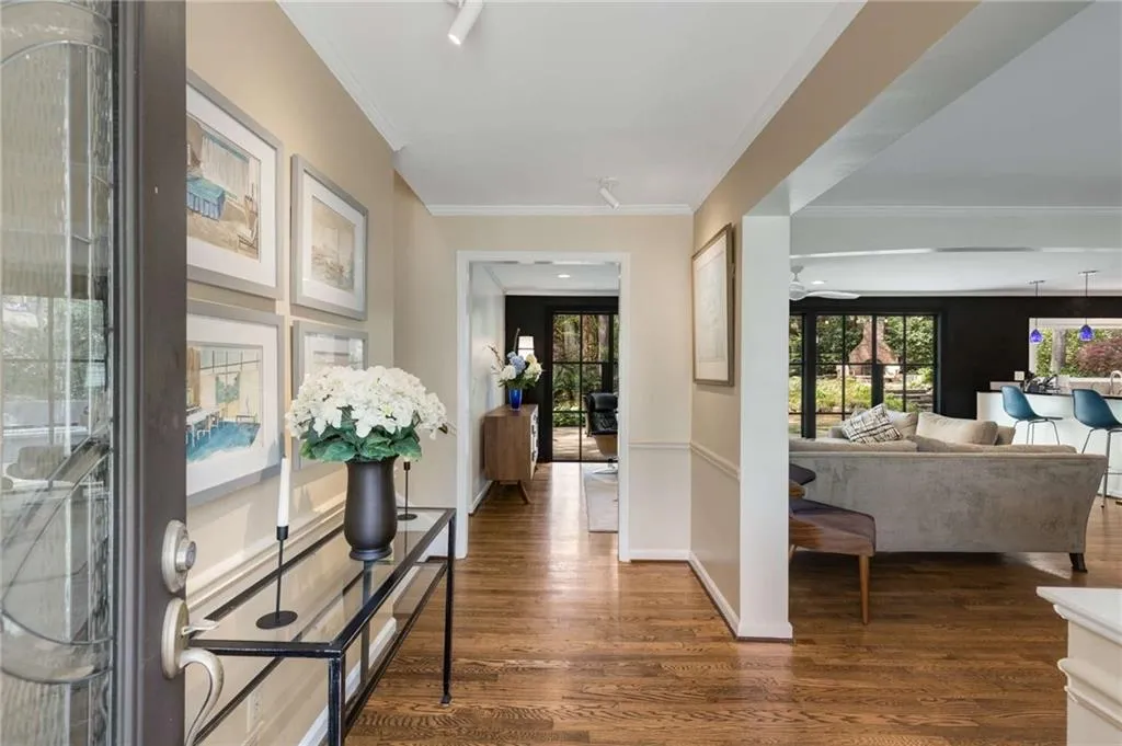 Entryway with ornamental molding, baseboards, and dark wood finished floors