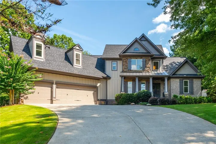 Stone and siding exterior with a multi-level roofline, prominent dormer windows, and a covered entry