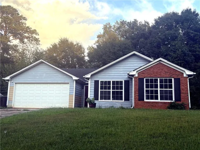 Single-story residence featuring a combination of brick and siding, a two-car garage, multiple pane windows with dark shutters, and a sloped front lawn