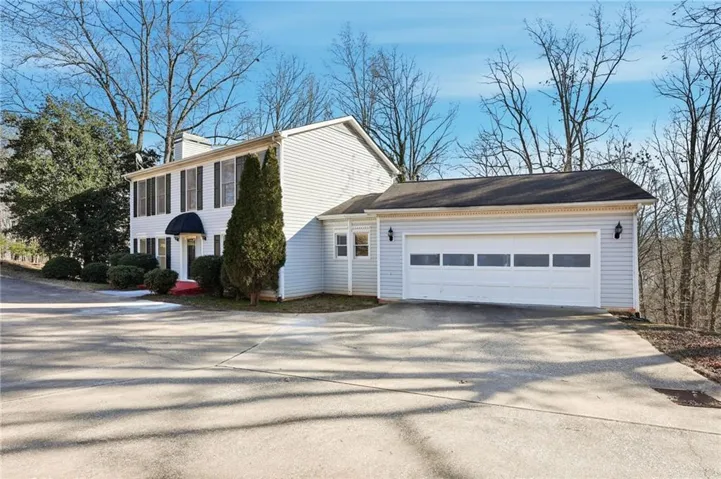 View of home's exterior with driveway, a garage, and a chimney