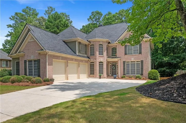 This traditional two-story home offers an impressive brick exterior, architectural detailing, mature landscaping, and a spacious three-car garage.