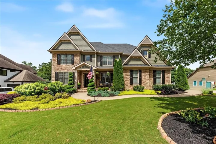 Front exterior featuring brick and siding accents, multiple gables, and a dark shingle roof